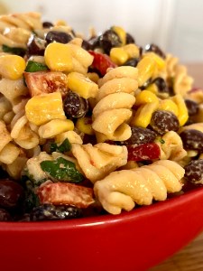 Close up of pasta salad brimming with beans and vegetablees.