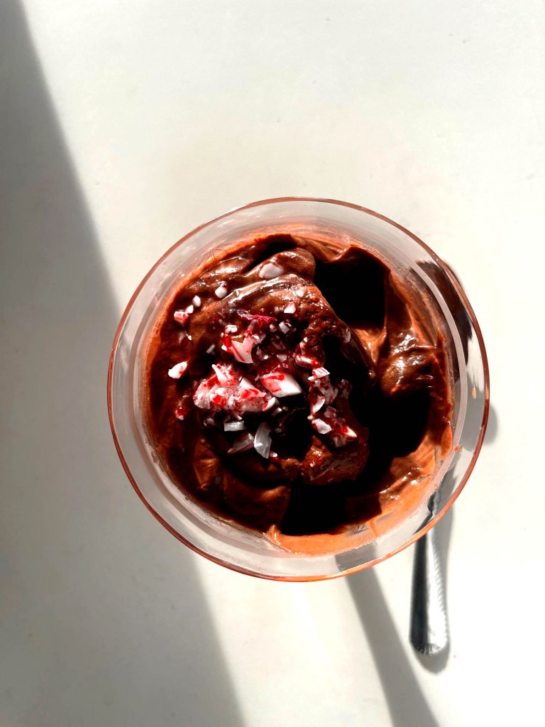 individual dish of vegan peppermint chocolate mousse garnished with crushed candy cane